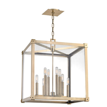 A lantern-shaped hanging light with exposed filament bulbs mounted on aged brass stems, suspended in a glass cube.